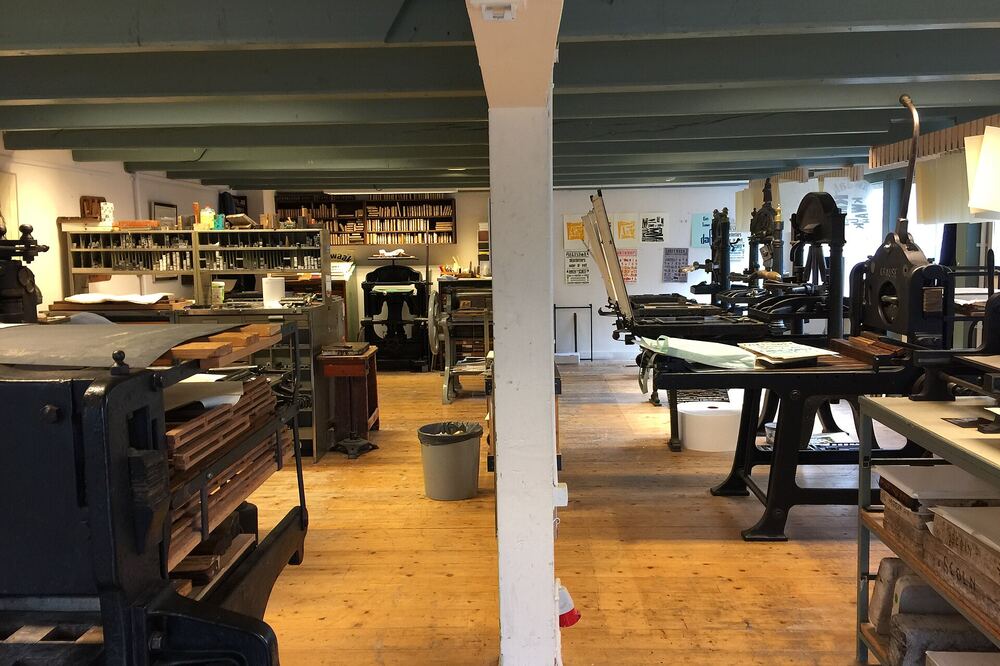 Zaal van het Drukkerijmuseum in Meppel met oude drukpersen en letterkasten op een houten vloer